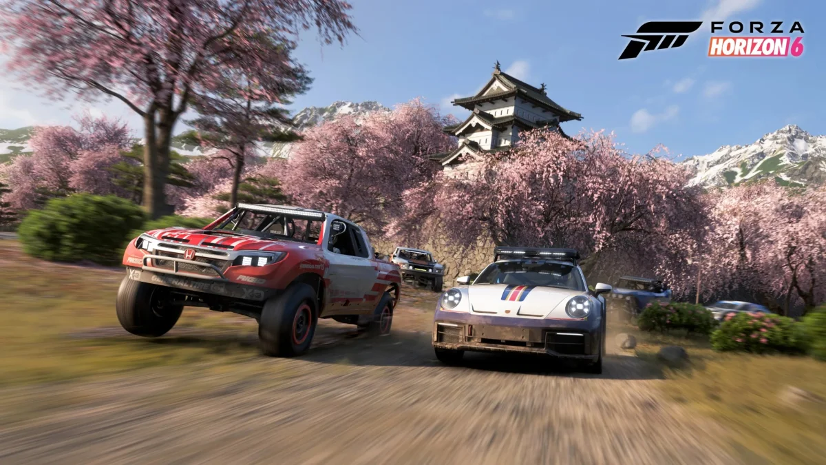 Forza Horizon 6 gameplay screenshot showing two drift cars racing through a cherry blossom road in Japan with a traditional Japanese castle in the background
